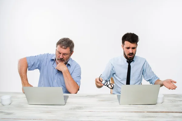 Los dos colegas que trabajan juntos en la oficina sobre fondo blanco —  Fotos de Stock