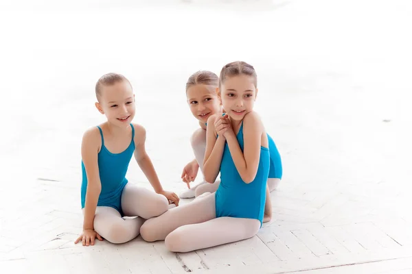Три маленькие балетные девочки сидят и разговаривают вместе — стоковое фото