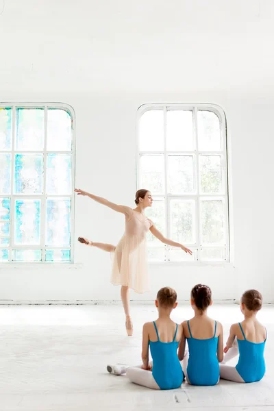 Tres pequeñas bailarinas bailando con un profesor de ballet personal en el estudio de baile — Foto de Stock