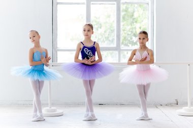 Three little ballet girls in tutu and posing together