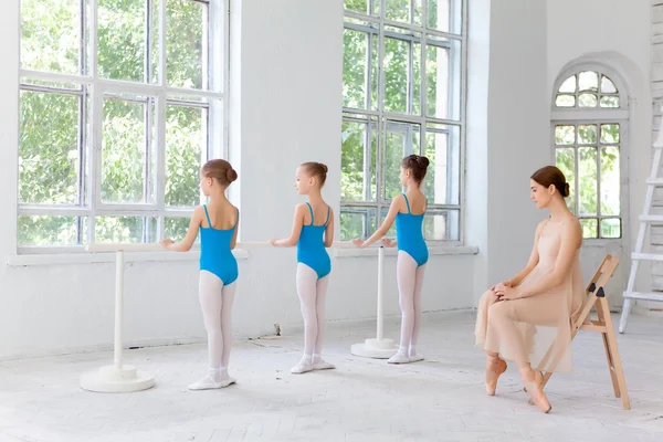 Tres pequeñas bailarinas bailando con un profesor de ballet personal en el estudio de baile — Foto de Stock