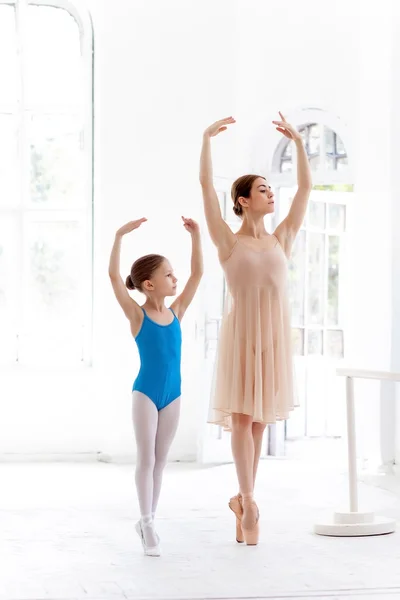 La pequeña bailarina posando en la barra de ballet con su profesora personal en el estudio de danza —  Fotos de Stock