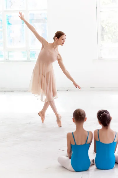 Dos pequeñas bailarinas bailando con un profesor de ballet personal en el estudio de baile — Foto de Stock
