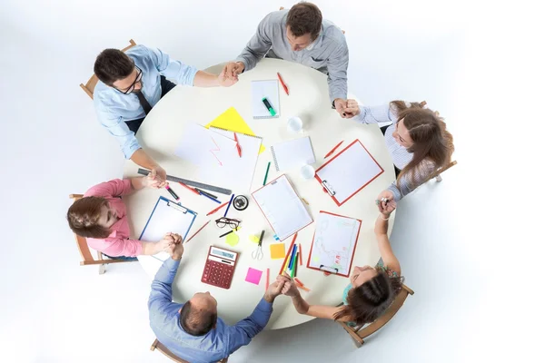 Vista superior. Manos unidas del equipo empresarial en el fondo del espacio de trabajo — Foto de Stock