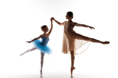 The little ballerina dancing with personal ballet teacher in dance studio