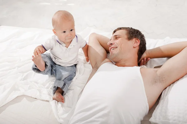 Young father with his nine months old son on the bed at home — Stock Photo, Image