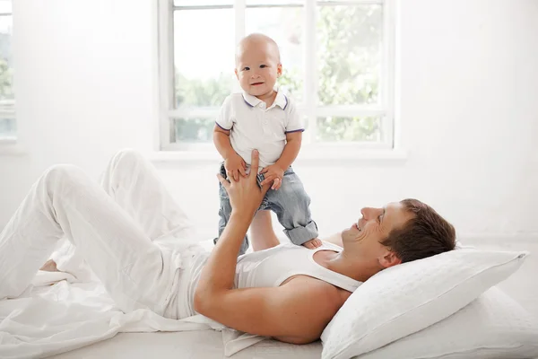 Young father with his nine months old son on the bed at home — Stock Photo, Image