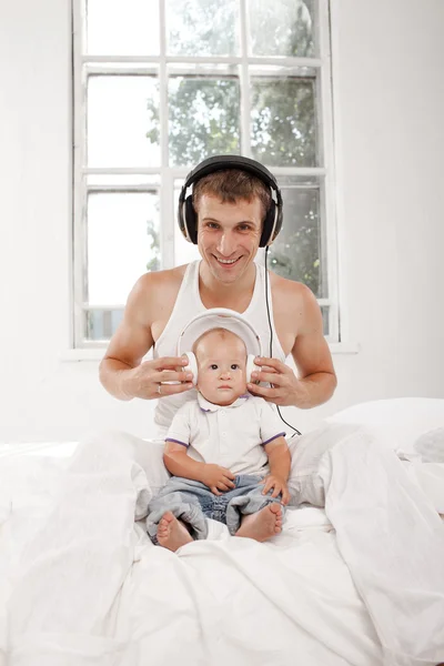 Young father with his nine months old som on the bed at home — Stock Photo, Image