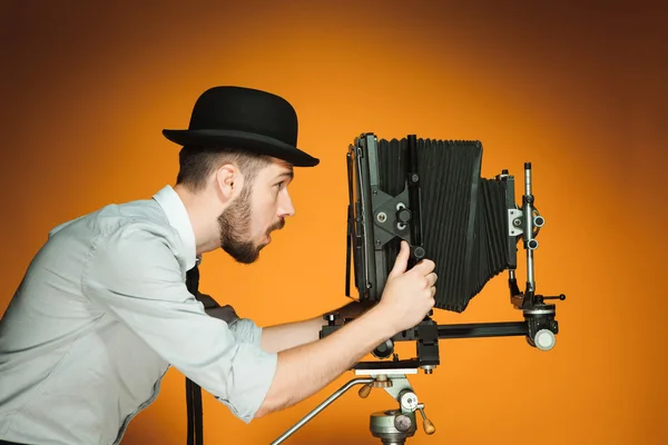 Young Positive Man Hat Photographer Looking Lens Retro Camera Orange — Stock Photo, Image