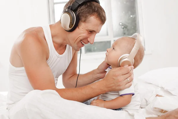 Young father with his nine months old som on the bed at home — Stock Photo, Image