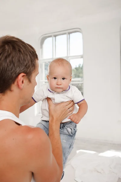 Young father with his nine months old son on the bed at home — Stock Photo, Image