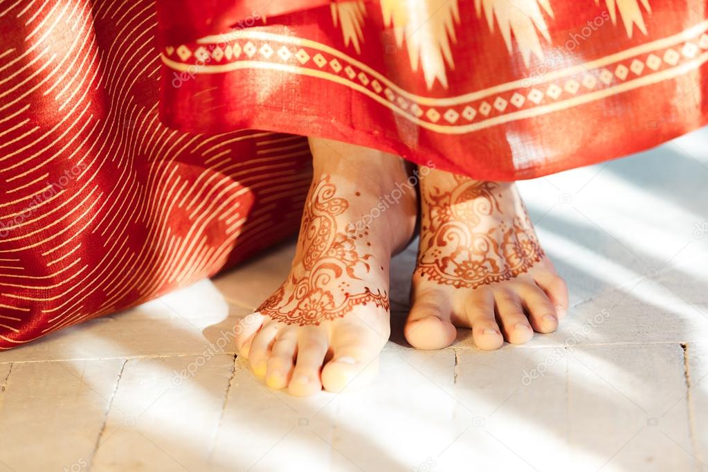 Legs decorated with indian mehandi painted henna close up