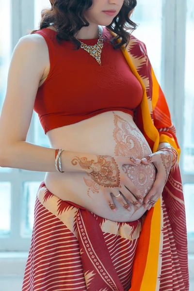 Gravid kvinna magen med henna tatuering — Stockfoto