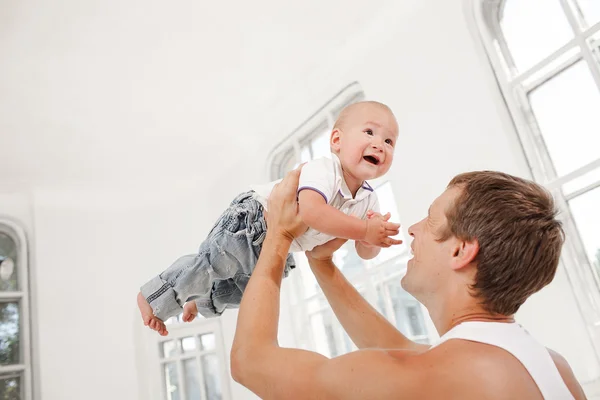 Jovem pai com seu filho de nove meses de idade em casa — Fotografia de Stock