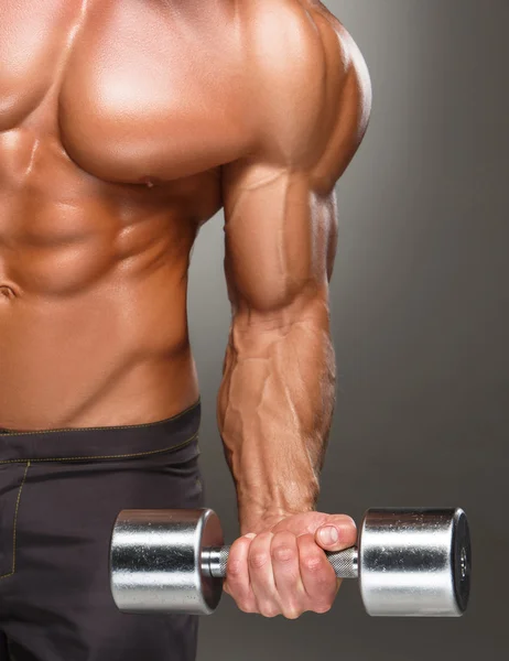 Dumbbell ile egzersizleri yapıyor bir yakışıklı güç atletik erkek vücut geliştirmeci closeup — Stok fotoğraf