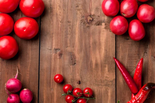 Červené zeleniny na dřevěný stůl — Stock fotografie