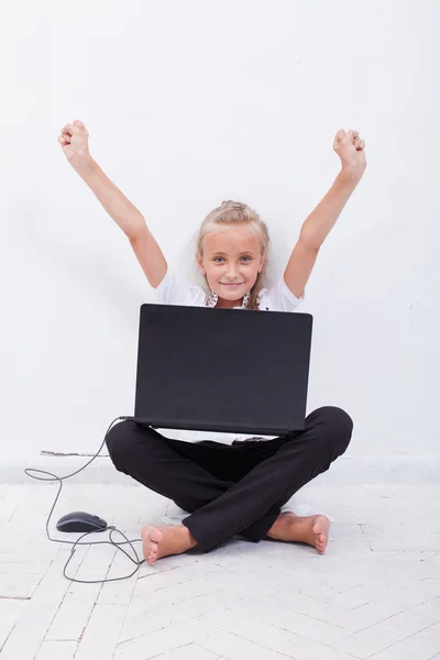Young teen girl with arms raised using laptop — 스톡 사진