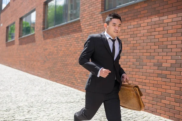 Jovem empresário chinês correndo em uma rua da cidade — Fotografia de Stock