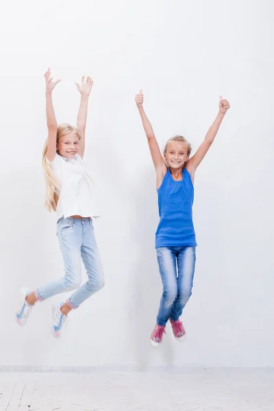 Grupo de jovens felizes pulando no fundo branco — Fotografia de Stock