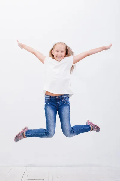 Šťastná mladá dívka, která skočila na bílém pozadí — Stock fotografie