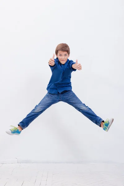 Счастливый мальчик прыгает на белом фоне — стоковое фото