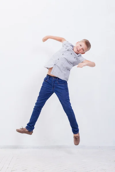 Menino feliz pulando no fundo branco — Fotografia de Stock