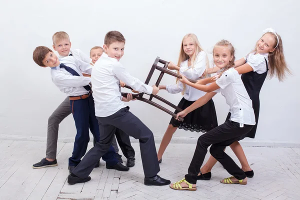 Kids playing tug of chair - girls versus boys, — Stock Photo, Image