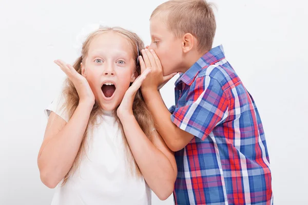 Tiener fluisteren in het oor een geheim aan tiener meisje op witte achtergrond — Stockfoto
