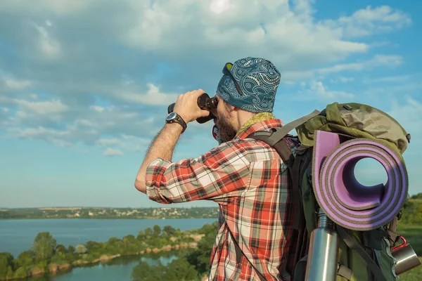 Jeune homme caucasien avec sac à dos debout sur le sommet de la colline — Photo