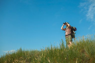 Sırt çantası ayakta tepenin üstünde genç beyaz adamla