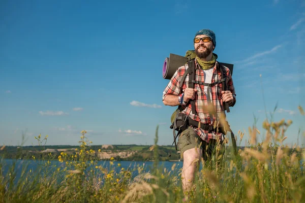 Kaukasische jongeman met rugzak staande op de top heuvel — Stockfoto