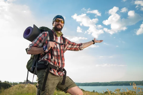 Kaukasische jongeman met rugzak staande op de top heuvel — Stockfoto