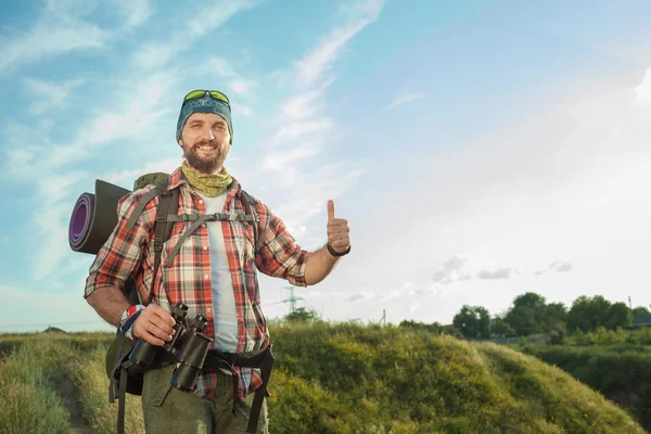 Kaukasische jongeman met rugzak staande op de top heuvel — Stockfoto