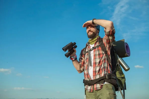 Jeune homme caucasien avec sac à dos debout sur le sommet de la colline — Photo