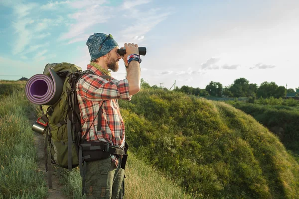 Jeune homme caucasien avec sac à dos debout sur le sommet de la colline — Photo