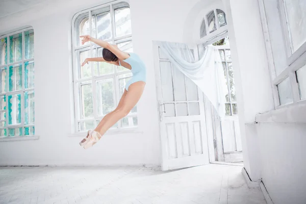 Молодой балетный танцор прыгает на белом фоне — стоковое фото