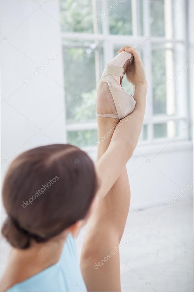 young modern ballet dancer posing on white background
