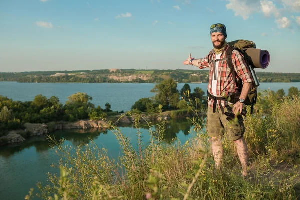 Jeune homme caucasien avec sac à dos debout sur le sommet de la colline — Photo