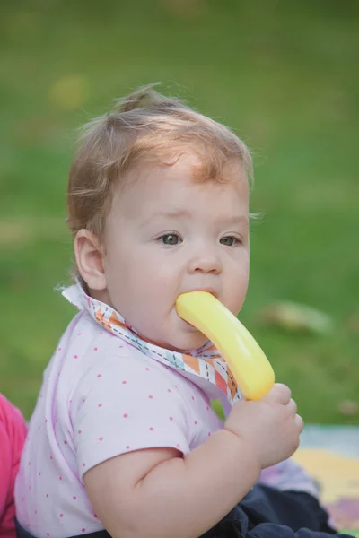 Bebê, menos de um ano de idade brincando com banana de brinquedo — Fotografia de Stock