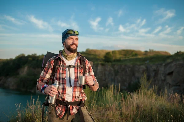 Joven hombre caucásico con mochila descansando y agua potable — Foto de Stock