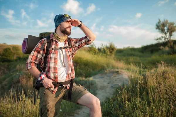 Kaukasische jongeman met rugzak op de top heuvel wandelen — Stockfoto