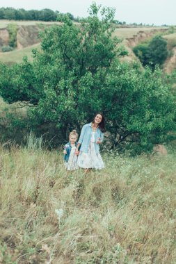 Genç anne ve kızı yeşil çim zemin üzerine