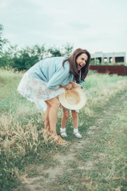 Genç anne ve kızı yeşil çim zemin üzerine