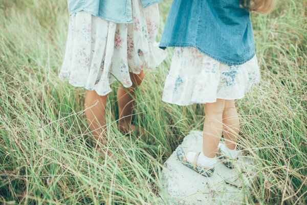 The young mother and daughter on green grass background