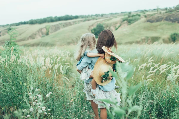 La joven madre y su hija en el fondo de hierba verde — Foto de Stock