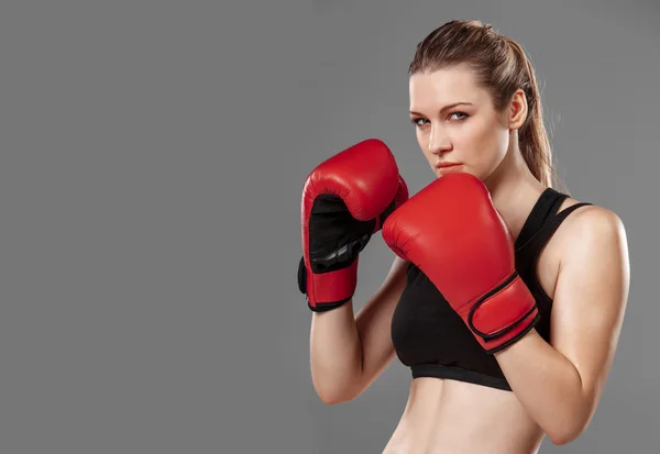 Beautiful woman is boxing on gray background — Stock Photo, Image