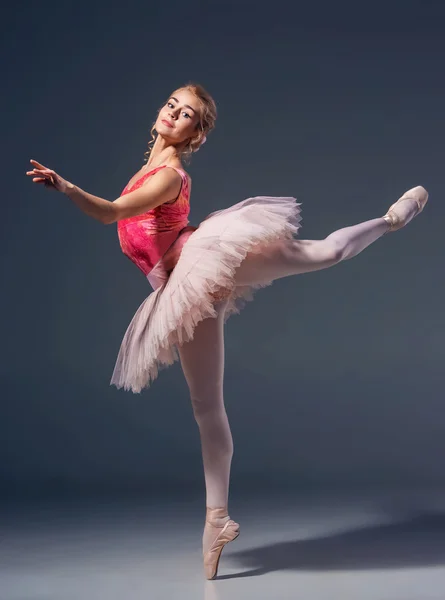 Красивая балетная танцовщица на сером фоне — стоковое фото