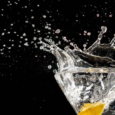 Canlı donmuş hareketle yakalanan limonlu berrak içecek sıçraması. İçecek için tazelik, berraklık ve neşe kavramı görsel, tasarım ve editoryal yaratıcılık.
