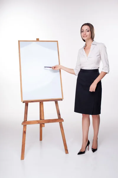 Молода бізнес-леді показує щось на білому тлі — стокове фото