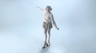 Samimi süveter giyen genç bayan buz patenci yumuşak ışıkta yavaşça donmuş yüzeyde dengede duruyor. Sakin kadınlık kavramı, kış keyfi nostaljisi, duygusal sükunet ve basit yaşam tarzı güzelliği..